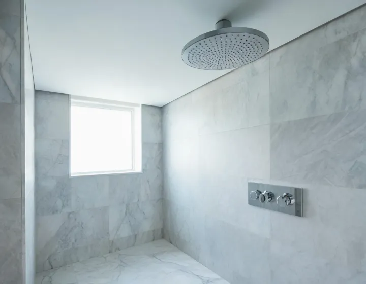 Hansgrohe rain shower and chrome fixtures in a modern hotel bathroom